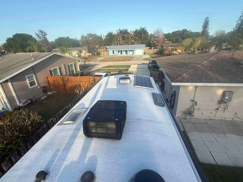 Mission RV technician replacing a rooftop AC unit on an RV at a Florida campground